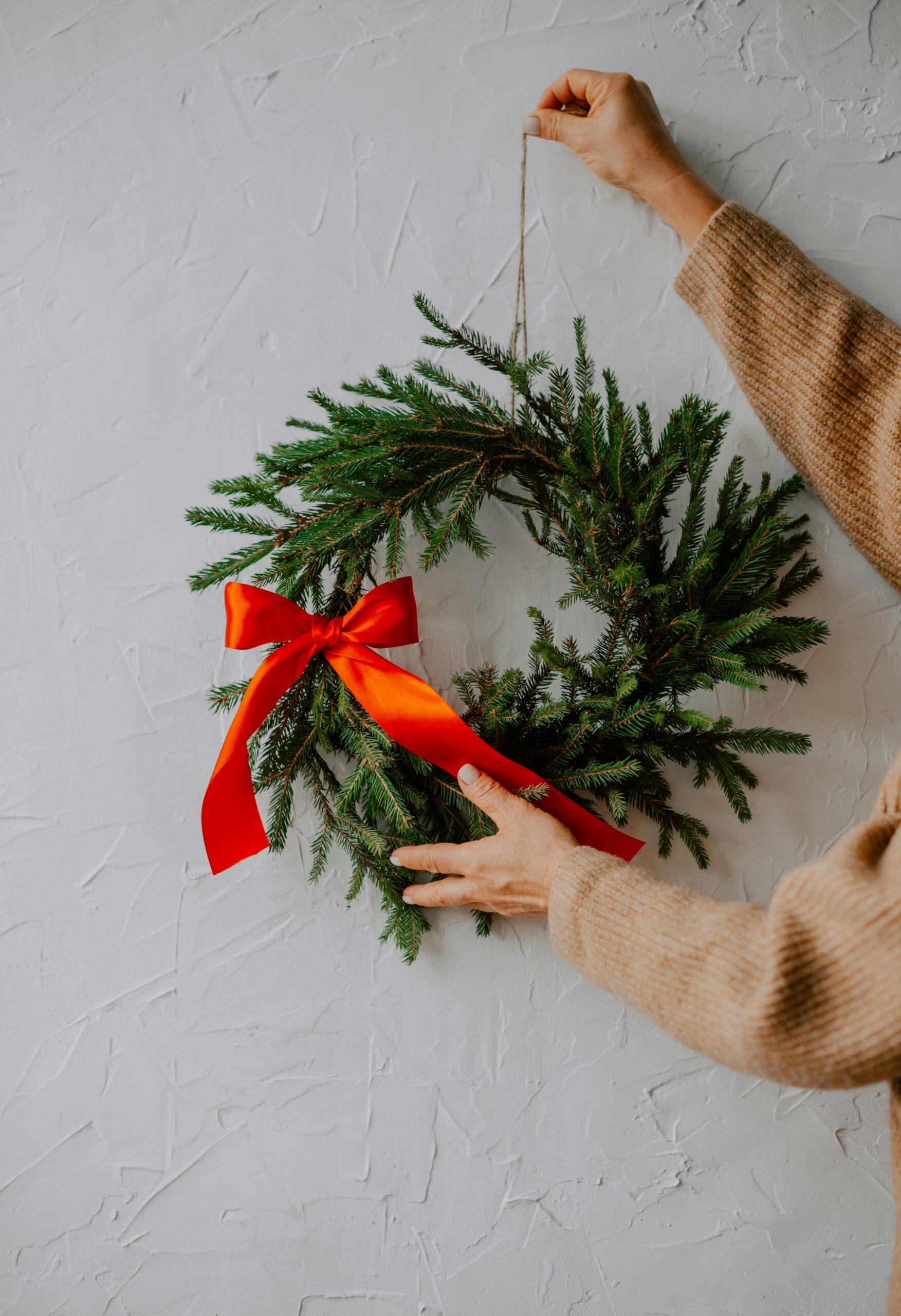 christmas bow being placed onto a wall 